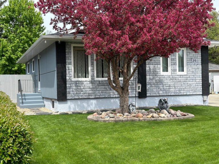 Stone and limestone exterior on a grey bungalow by Brandt Plastering